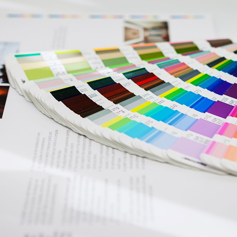 Nuancier de couleurs Pantone ouvert sur des documents d'impression. Des centaines d'échantillons de couleurs vives pour le design graphique.